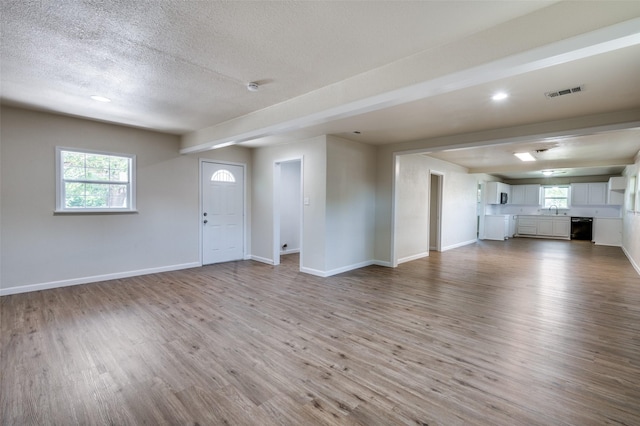 5217 Mack Rd, Haltom City, TX 76117 - unfurnished living room featuring light wood-style floors, baseboards, a textured ceiling, healthy amount of natural light, and recessed lighting