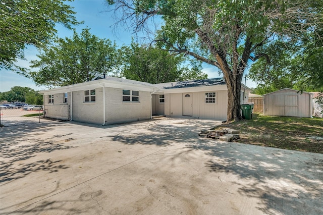 5217 Mack Rd, Haltom City, TX 76117 - view of front of property featuring a patio, fence, a storage shed, concrete driveway, and brick siding