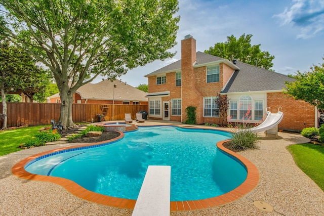 view of pool with a fenced backyard, a water slide, a patio area, a diving board, and a pool with connected hot tub