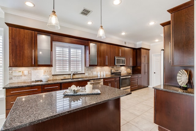kitchen with stainless steel appliances, a sink, backsplash, decorative light fixtures, and crown molding