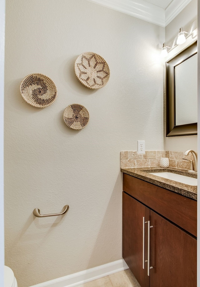 bathroom featuring vanity, toilet, and baseboards