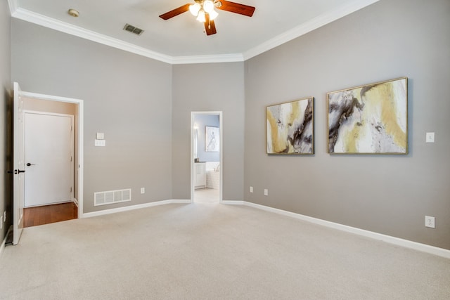 unfurnished bedroom featuring crown molding, carpet flooring, baseboards, connected bathroom, and ceiling fan