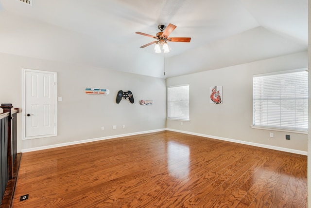 spare room featuring ceiling fan, lofted ceiling, wood finished floors, and baseboards