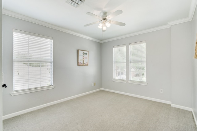 spare room with crown molding, ceiling fan, baseboards, and light colored carpet