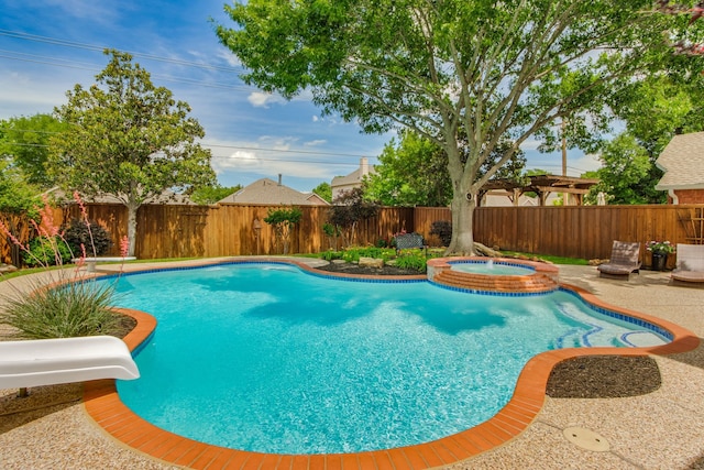 view of pool with a water slide, a fenced backyard, and a pool with connected hot tub
