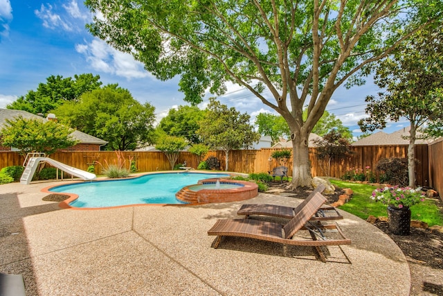 view of swimming pool with a water slide, a fenced backyard, a patio, and a pool with connected hot tub