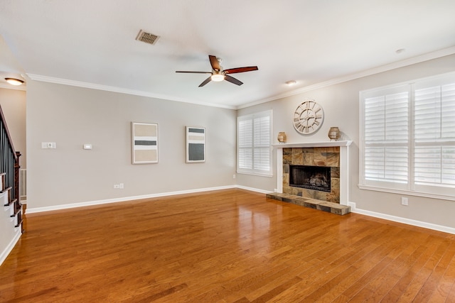 unfurnished living room featuring a ceiling fan, a fireplace, wood finished floors, stairway, and baseboards