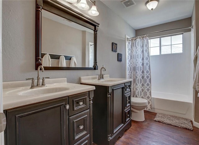 5315 Summit Knoll Trl, Sachse, TX 75048 - bathroom with wood finished floors, two vanities, toilet, and shower / bathtub combination with curtain
