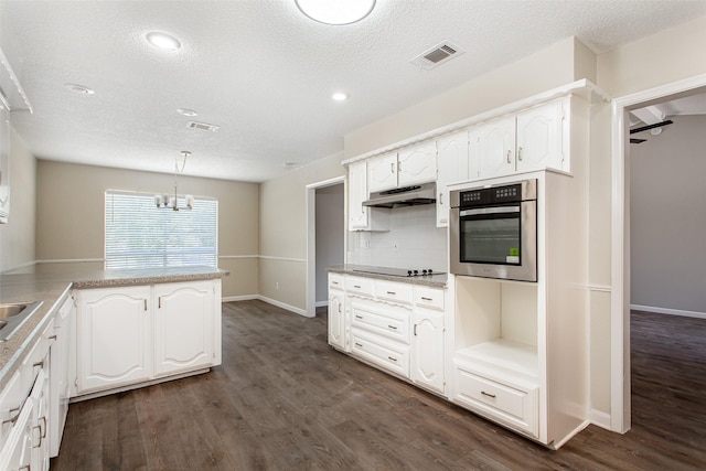 7102 Timberline Dr, Rowlett, TX 75089 - kitchen featuring stainless steel oven, under cabinet range hood, black electric stovetop, a textured ceiling, and dark wood finished floors