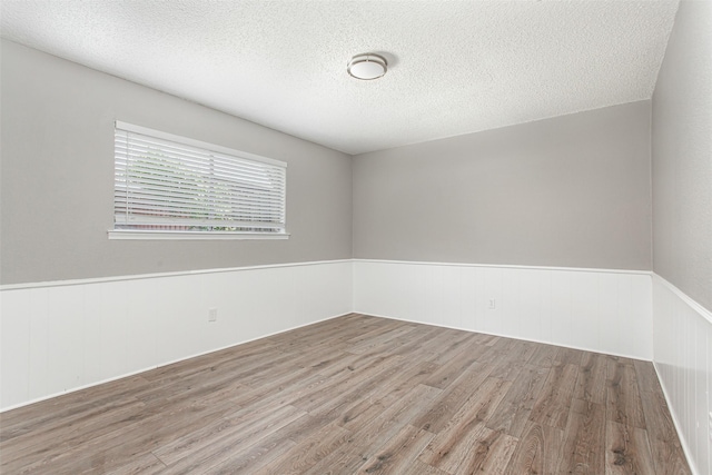 7102 Timberline Dr, Rowlett, TX 75089 - unfurnished room with wainscoting, wood finished floors, and a textured ceiling