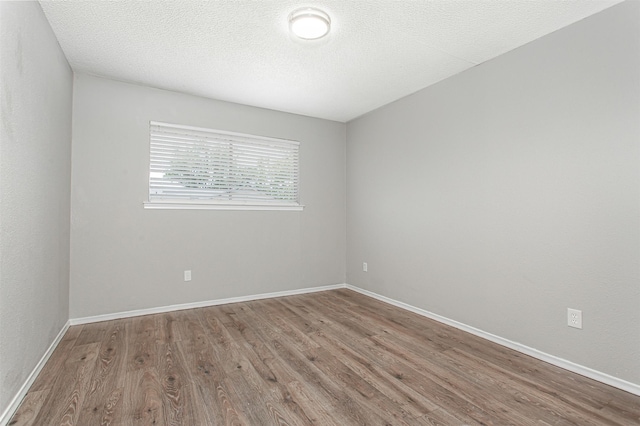 7102 Timberline Dr, Rowlett, TX 75089 - spare room with wood finished floors, baseboards, and a textured ceiling