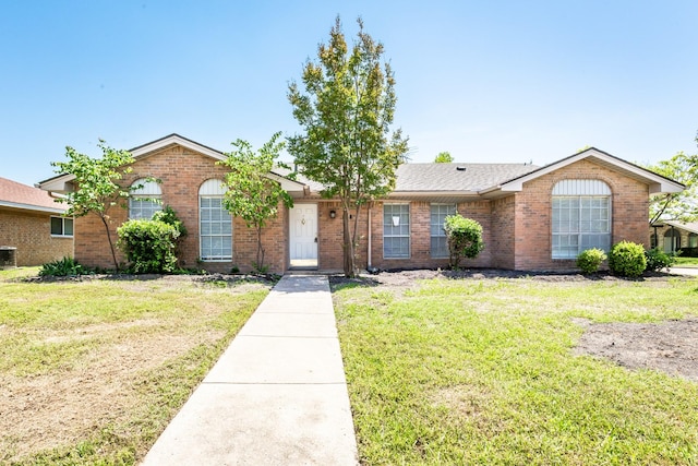 7102 Timberline Dr, Rowlett, TX 75089 - ranch-style house with brick siding, a front yard, and central AC unit