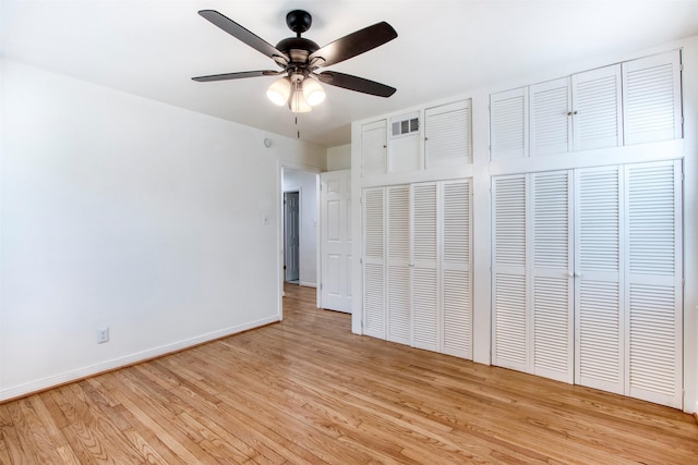 11521 Fernald Ave, Dallas, TX 75218 - unfurnished bedroom with light wood finished floors, multiple closets, baseboards, and a ceiling fan