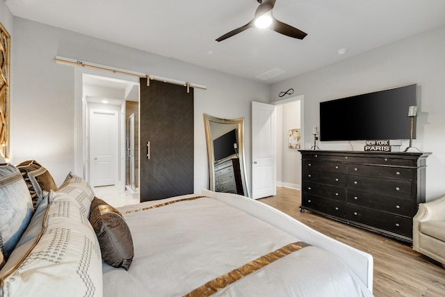 507 N Eagle Point Rd, Van Alstyne, TX 75495 - bedroom featuring wood finished floors, a ceiling fan, baseboards, and a barn door