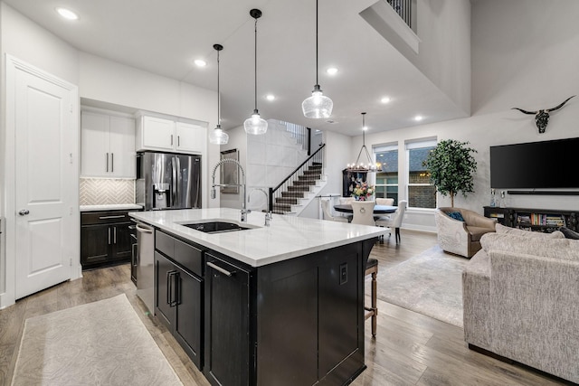 507 N Eagle Point Rd, Van Alstyne, TX 75495 - kitchen featuring stainless steel appliances, a sink, open floor plan, light wood-type flooring, and dark cabinets