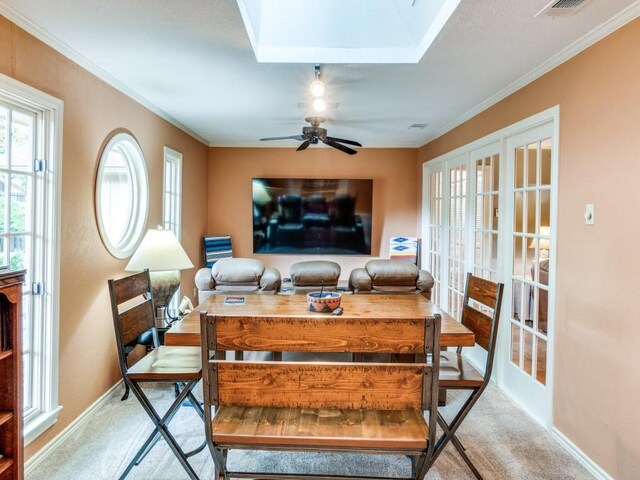 12151 Crestline Ave, Dallas, TX 75244 - carpeted dining room featuring french doors, a ceiling fan, baseboards, crown molding, and a skylight