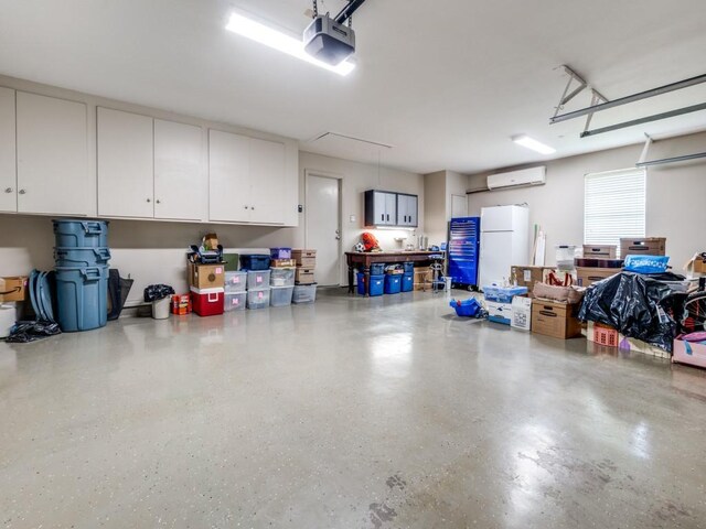 12151 Crestline Ave, Dallas, TX 75244 - garage with freestanding refrigerator, a garage door opener, and a wall unit AC