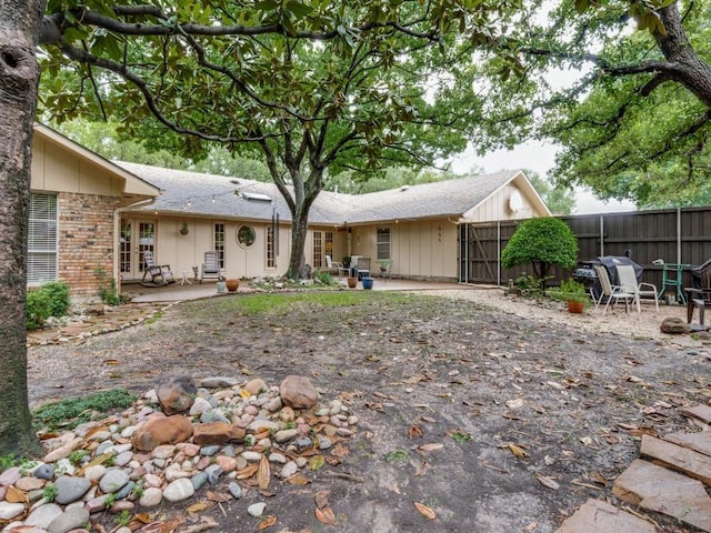 12151 Crestline Ave, Dallas, TX 75244 - back of property with fence, french doors, a patio area, roof with shingles, and board and batten siding