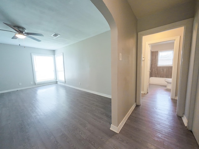 4318 York St, Dallas, TX 75210 - empty room featuring arched walkways, ceiling fan, dark wood finished floors, and baseboards