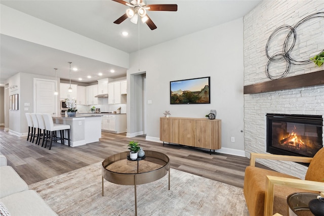 2415 Preakness Pl, Celina, TX 75009 - living area with a ceiling fan, light wood finished floors, a stone fireplace, baseboards, and recessed lighting