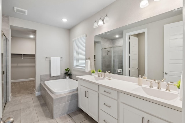2415 Preakness Pl, Celina, TX 75009 - full bathroom featuring a shower stall, double vanity, a garden tub, tile patterned floors, and a walk in closet