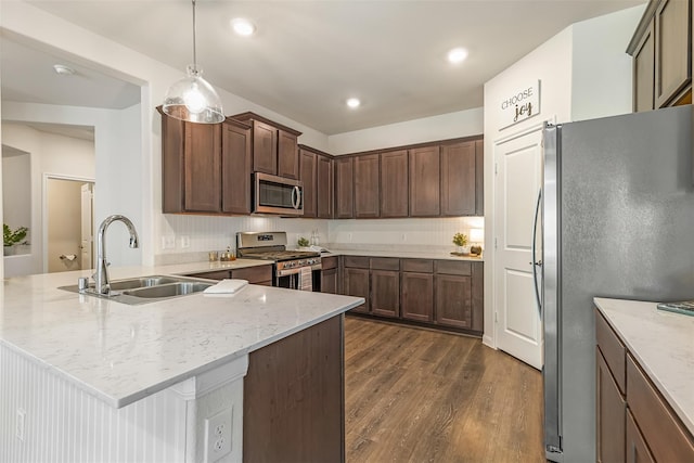 3932 Oak Creek Cir, Denison, TX 75020 - kitchen featuring stainless steel appliances, a sink, a peninsula, dark wood-style flooring, and light stone counters