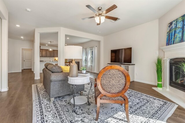 3932 Oak Creek Cir, Denison, TX 75020 - living area with wood finished floors, ceiling fan, baseboards, a glass covered fireplace, and recessed lighting