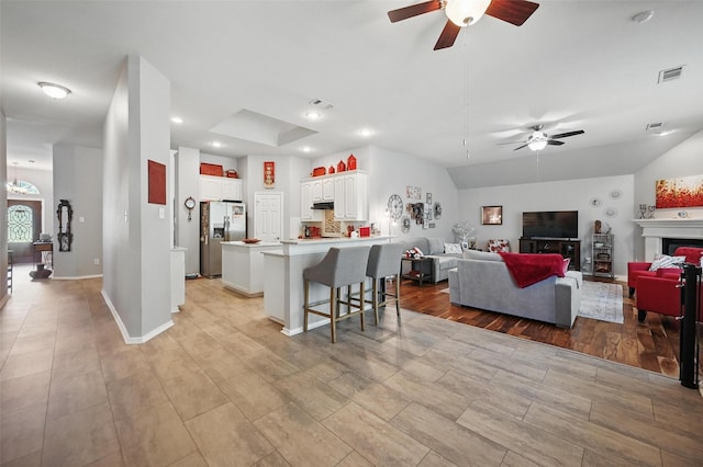 2813 Calico Rock Dr, Fort Worth, TX 76131 - kitchen featuring ceiling fan, stainless steel refrigerator with ice dispenser, a kitchen breakfast bar, white cabinets, and light countertops
