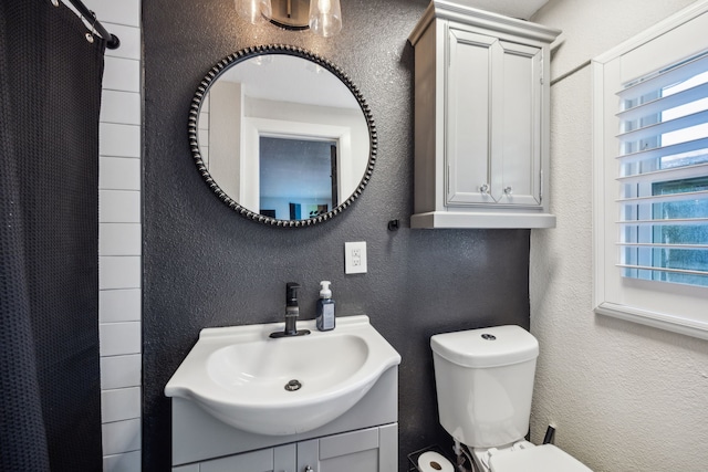 8538 Grenadier Dr, Dallas, TX 75238 - full bath with a textured wall, toilet, vanity, and curtained shower