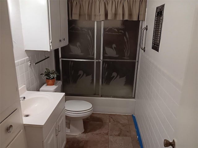 12249 High Pointe Cir, Dallas, TX 75243 - bathroom with tile walls, toilet, vanity, and bath / shower combo with glass door
