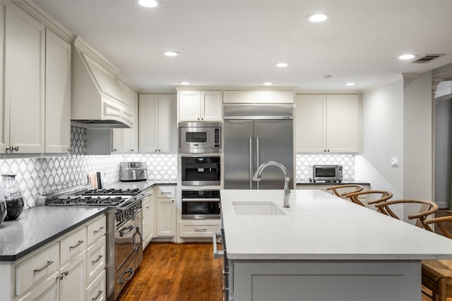 4710 Bobbitt Dr, Dallas, TX 75229 - kitchen with built in appliances, a sink, decorative backsplash, a breakfast bar area, and recessed lighting