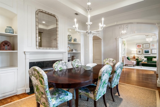 4710 Bobbitt Dr, Dallas, TX 75229 - dining area with built in features, light wood-type flooring, decorative columns, ornamental molding, and arched walkways