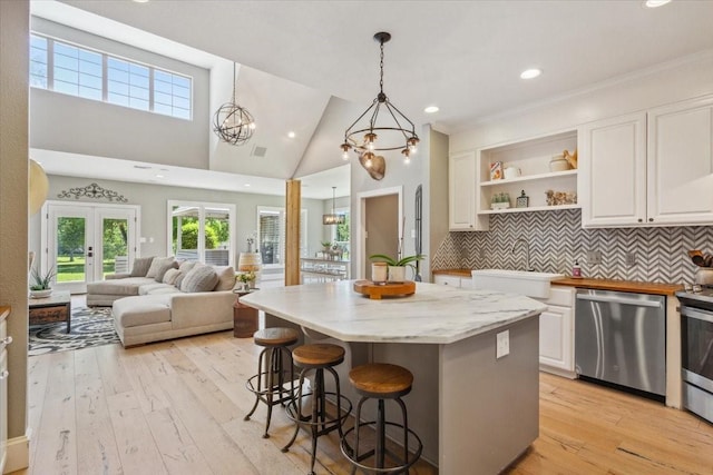 1345 Stillwater Rd, Waco, TX 76708 - kitchen with stainless steel appliances, a sink, white cabinetry, light wood-style flooring, and open floor plan