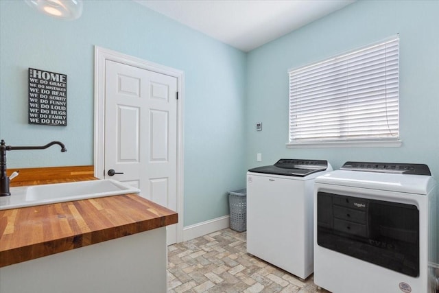 1345 Stillwater Rd, Waco, TX 76708 - laundry room with separate washer and dryer, brick patterned floors, and baseboards