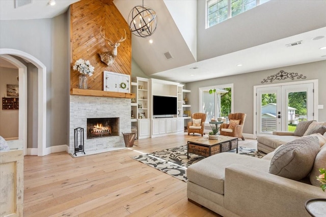 1345 Stillwater Rd, Waco, TX 76708 - living room with a towering ceiling, plenty of natural light, light wood-style floors, arched walkways, and a stone fireplace