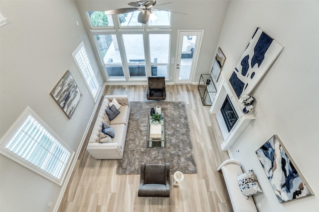 12523 Royal Oaks Ln, Farmers Branch, TX 75234 - living area with a towering ceiling, wood finished floors, ceiling fan, and a glass covered fireplace