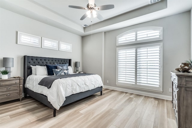 12523 Royal Oaks Ln, Farmers Branch, TX 75234 - bedroom with a tray ceiling, light wood-style flooring, baseboards, and ceiling fan