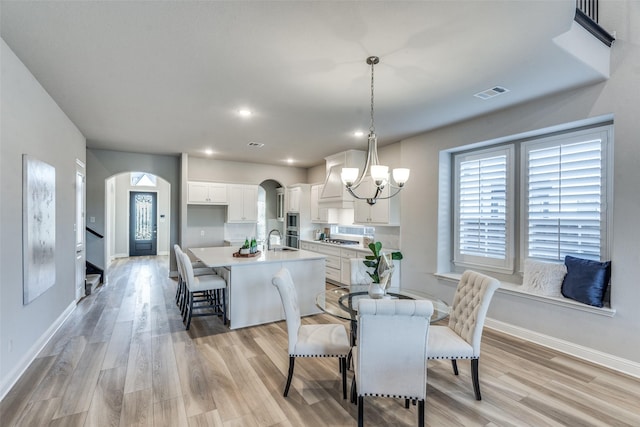 12523 Royal Oaks Ln, Farmers Branch, TX 75234 - dining space with arched walkways, baseboards, light wood-type flooring, a chandelier, and recessed lighting
