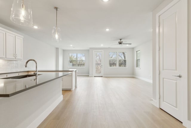 8289 Emsworth Dr, Dallas, TX 75231 - kitchen with a sink, recessed lighting, a ceiling fan, decorative backsplash, and baseboards