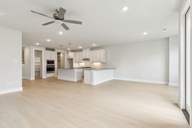 8289 Emsworth Dr, Dallas, TX 75231 - unfurnished living room with a ceiling fan, recessed lighting, light wood-style floors, baseboards, and a sink
