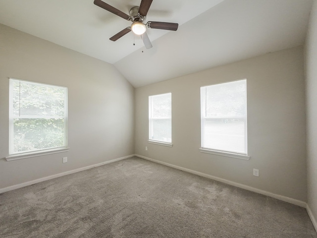 carpeted spare room featuring ceiling fan, baseboards, and lofted ceiling