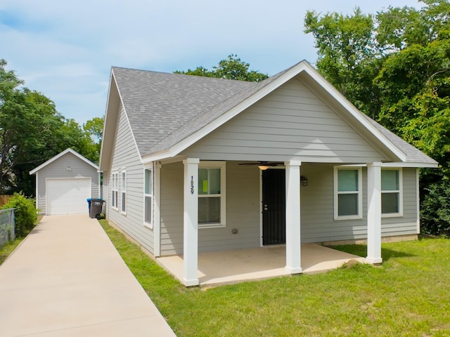 view of front of property with a detached garage, an outdoor structure, roof with shingles, concrete driveway, and ceiling fan