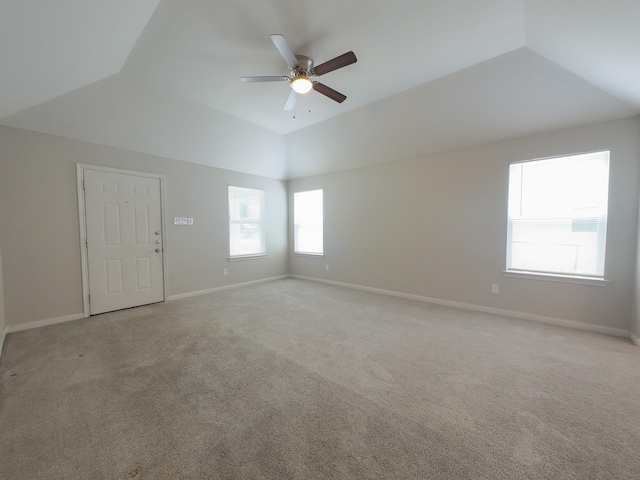 unfurnished room with lofted ceiling, light colored carpet, a ceiling fan, and baseboards