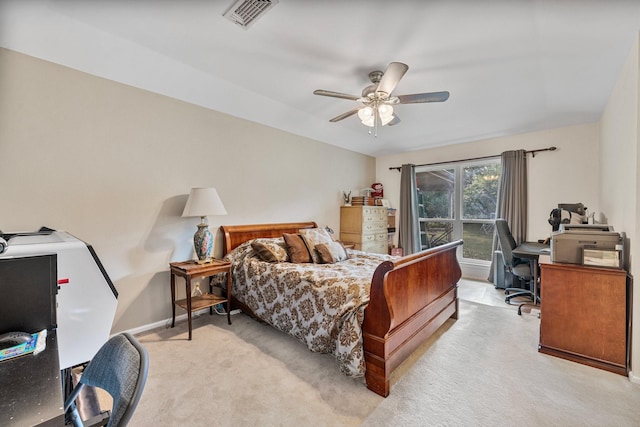 bedroom featuring light carpet, an office area, baseboards, and a ceiling fan