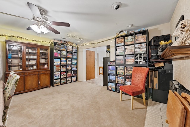 living area with a ceiling fan and carpet flooring