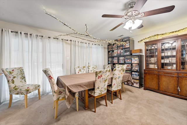 dining area with light carpet and a ceiling fan