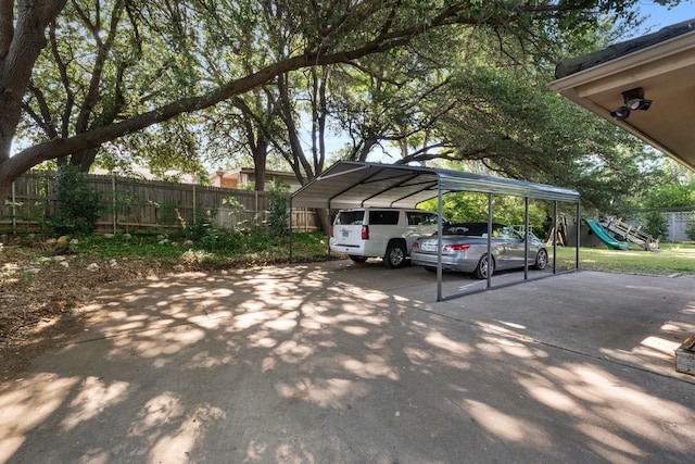 view of parking with a detached carport, fence, driveway, and a playground