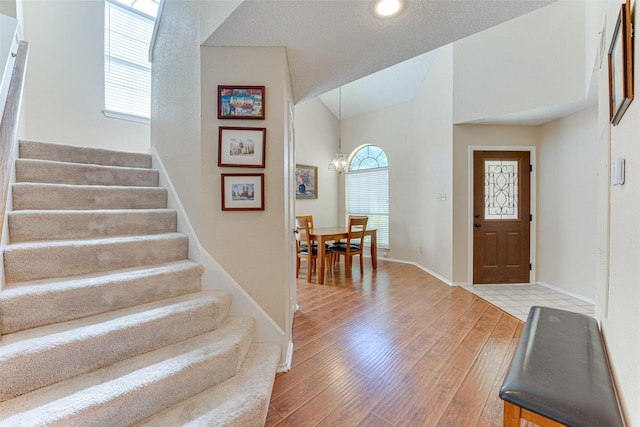 3817 Roman Ct, Plano, TX 75023 - foyer with stairway, wood finished floors, baseboards, vaulted ceiling, and a chandelier