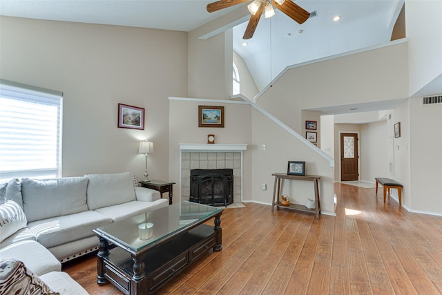 3817 Roman Ct, Plano, TX 75023 - living area with high vaulted ceiling, ceiling fan, stairway, wood finished floors, and a tiled fireplace