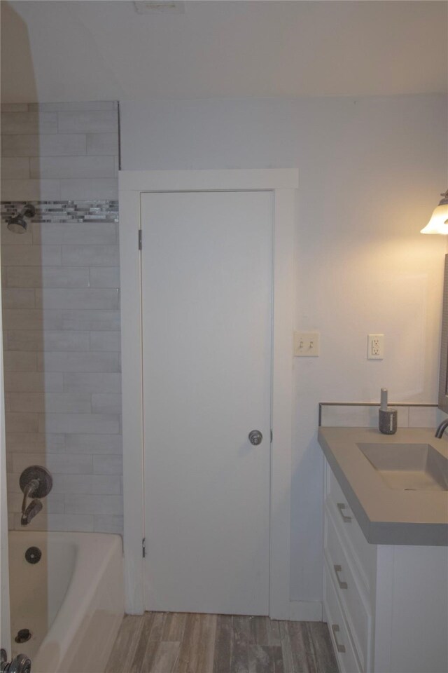 1524 Daywood Ln, Irving, TX 75061 - full bathroom featuring wood finished floors, vanity, and shower / washtub combination
